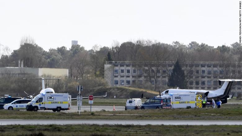 A Covid-19 patient is carried into an ambulance at a Paris airport on Sunday, ahead of their transfer to a hospital in another region. 