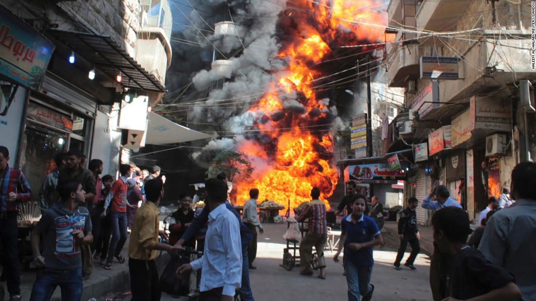 Residents run from a fire at a gasoline and oil shop in Aleppo&#39;s Bustan Al-Qasr neighborhood on October 20, 2013. Witnesses said the fire was caused by a bullet from a pro-government sniper.