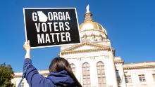 ATLANTA, GA - MARCH 03: Demonstrators stand outside of the Georgia Capitol building, to oppose the HB 531 bill on March 3, 2021 in Atlanta, Georgia. HB 531 will add controversial voting restrictions to the state&#39;s upcoming elections including restricting ballot drop boxes, requiring an ID requirement for absentee voting and limiting weekend early voting days. The Georgia House passed the bill and will send it to the Senate. (Photo by Megan Varner/Getty Images)