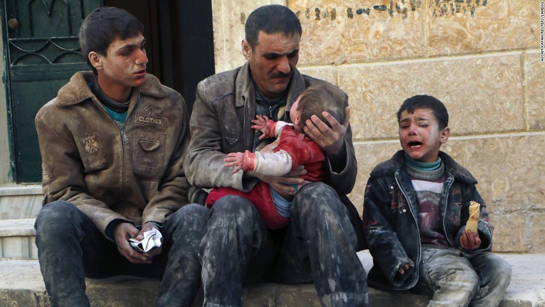 A man holds a baby who was rescued from rubble after an airstrike in Aleppo on February 14, 2014.
