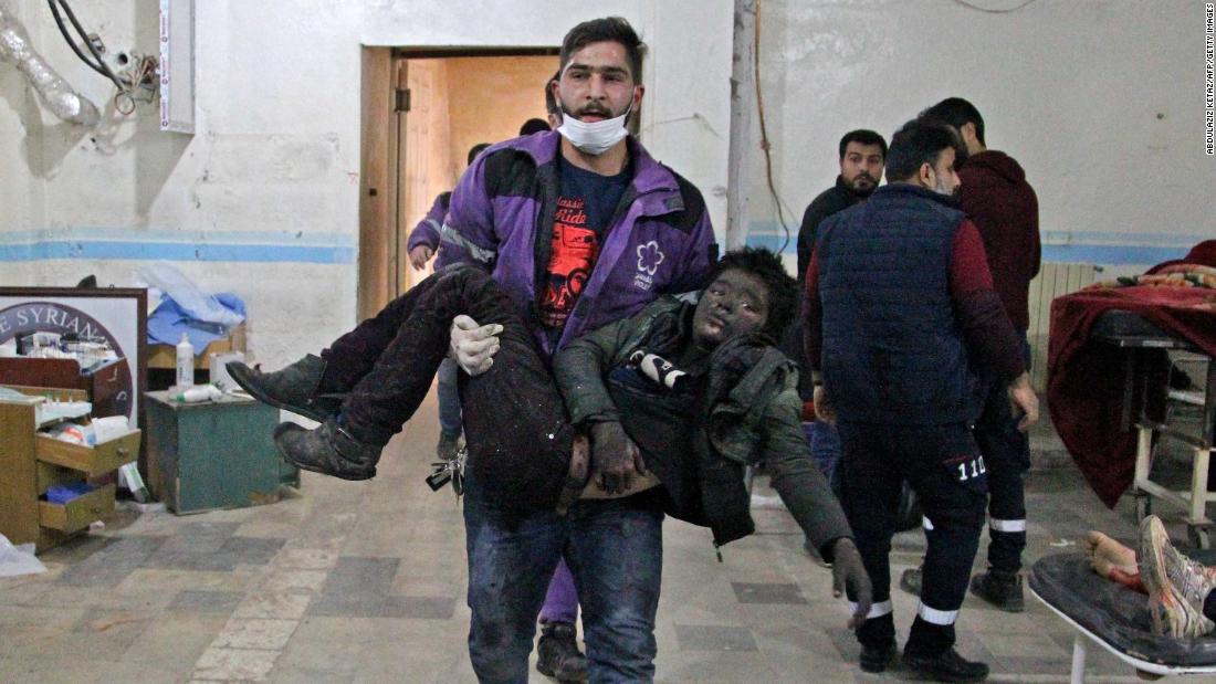 A member of the Syrian Violet Organization carries an injured boy at a makeshift hospital following a regime air strike on a vegetable market in Syria&#39;s last major opposition bastion of Idlib on January 15, 2020.