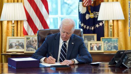 US President Joe Biden signs the American Rescue Plan on March 11, 2021, in the Oval Office of the White House in Washington, DC. - Biden signed the $1.9 trillion economic stimulus bill and will give a national address urging &quot;hope&quot; on the first anniversary of the start of the coronavirus pandemic. (Photo by MANDEL NGAN / AFP) (Photo by MANDEL NGAN/AFP via Getty Images)