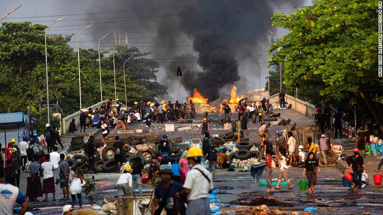 Chaotic scenes of makeshift barricades on a bridge set on fire by police during a demonstration against the military coup in Yangon. 
