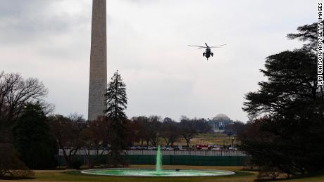 Marine One, carrying US President Joe Biden, flies over the fountain,dyed green for St. Patrick&#39;s Day on the South Lawn of the White House, as he arrives on March 17, 2021. 
