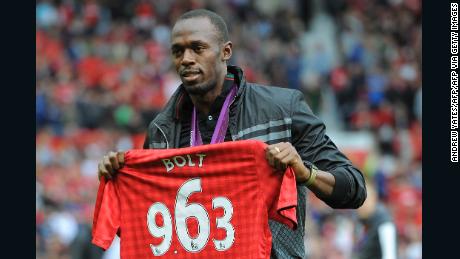 Usain Bolt on the pitch at Old Trafford with a United shirt displaying the time in which he won the 100m final at London 2012.