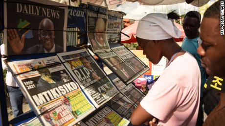 People read newspapers announcing the death of President John Magufuli in Dar es Salaam, Tanzania, on March 18, 2021.