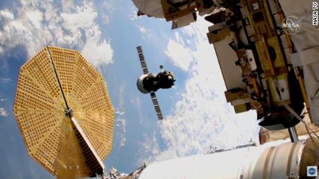La navicella Soyuz può essere vista in volo al centro di questa immagine.