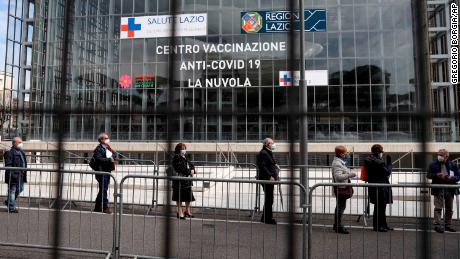 People queue to receive an AstraZeneca shot at a Rome convention center, temporarily turned into a Covid-19 vaccination hub, on Friday, March 19.