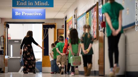 Masked students march in line in the main hallway as they socialize past Medora Elementary School in Louisville, Kentucky. 