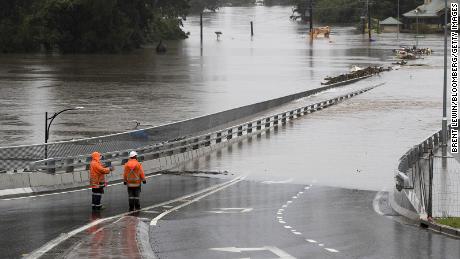 Les contrôleurs de la circulation se tiennent au Hawkesbury River Bridge submergé par les eaux de crue à Windsor, en Nouvelle-Galles du Sud, le 22 mars.