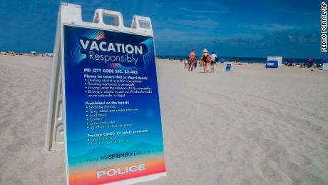 A sign on the beach earlier this month warns spring breakers to vacation safely.