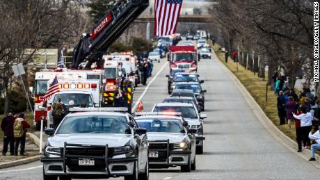 Des véhicules des forces de l'ordre escortent le corps de l'officier de police de Boulder tué Eric Talley jusqu'à un salon funéraire le 24 mars 2021.