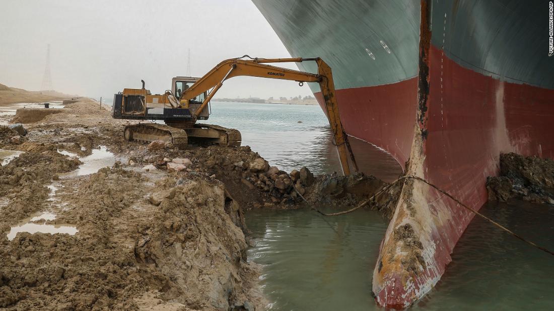 An excavator removes mud and sand from around the bow of the Ever Given on Thursday.