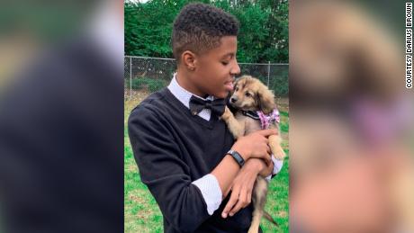 Darius Brown with a shelter dog that&#39;s wearing one of his bow ties.