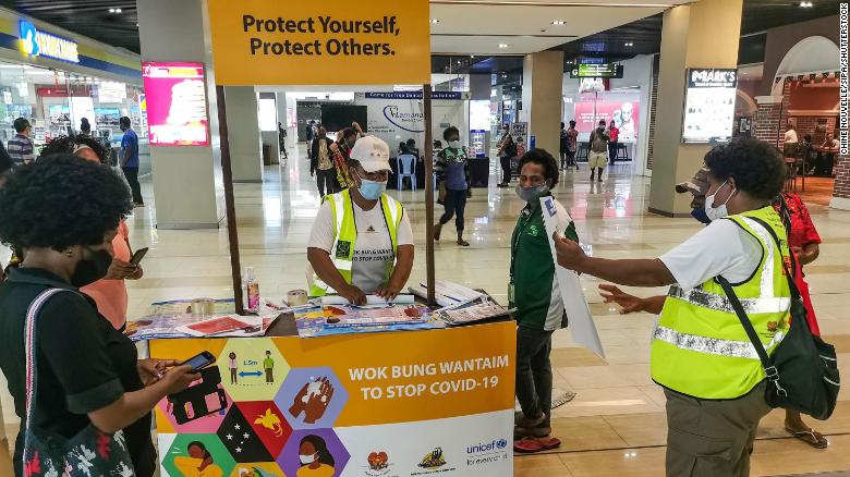 La gente aprende cómo prevenir la Covid-19 en un centro comercial en la capital, Port Moresby, el 4 de septiembre de 2020. 
