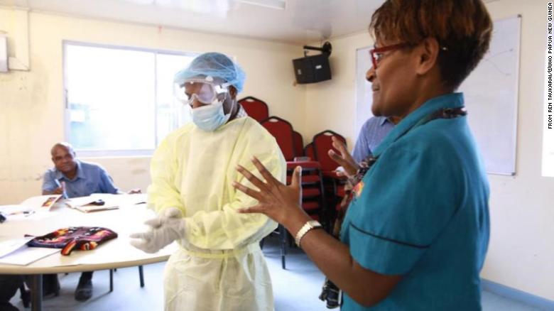 Janlyn Kumbu, del Laboratorio Central de Salud Pública de PNG, capacita a los trabajadores de la salud en Vanimo, West Sepik, sobre los procedimientos adecuados de EPP.
