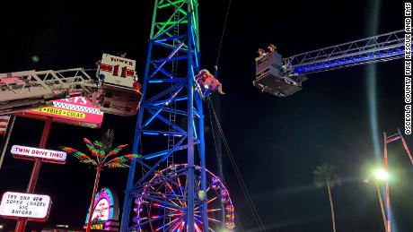 Two Florida teens were suspended on a slingshot ride around three stories high after a cable snapped, officials say.