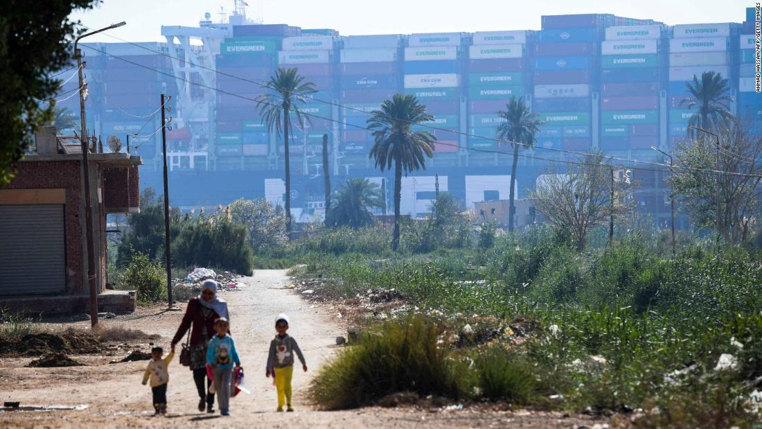 A woman walks with children near the ship on Saturday.
