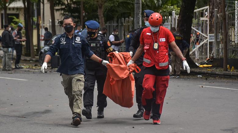 Indonesian police carry the remains of a suspected suicide bomber after an explosion outside a church in Makassar on March 28.