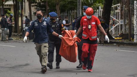 Indonesian police carry the remains of a suspected suicide bomber after an explosion outside a church in Makassar on March 28.