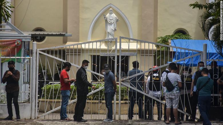 Indonesian police examine the site outside a church after an explosion in Makassar on March 28.