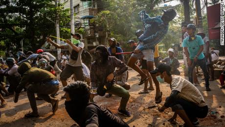Anti-coup protesters use slingshots and pelt stones towards approaching security forces on March 28 in Yangon, Myanmar. 