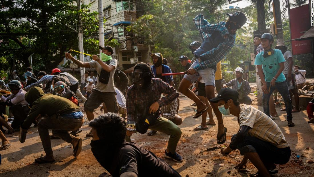 Protesters throw stones and use slingshots as security forces approached in Yangon on March 28.