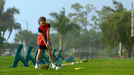 Pano lines up a shot on the driving range. 