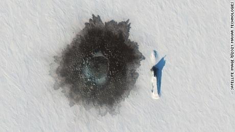 Un submarin rusesc Delta IV fotografiat peste gheață lângă insula Alexandra pe 27 martie, în timpul unui exercițiu, cu o gaură probabil aruncată în gheață la stânga în urma unei demolări subacvatice.
