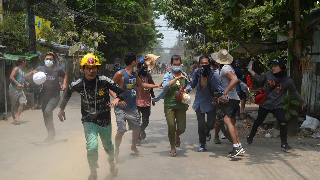 Protesters run to avoid the military in Yangon on March 30.