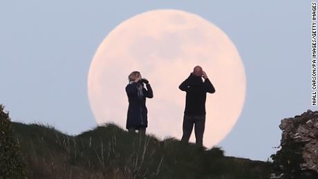 O lună gigant roz se ridică peste stâncoasa Dunamacey din județul Laois din Republica Irlanda.