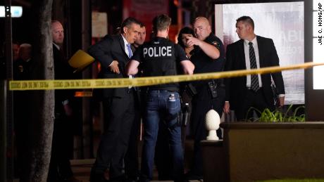 Investigators gather outside an office building where a shooting took place in Orange, Calif. On Wednesday, March 31.