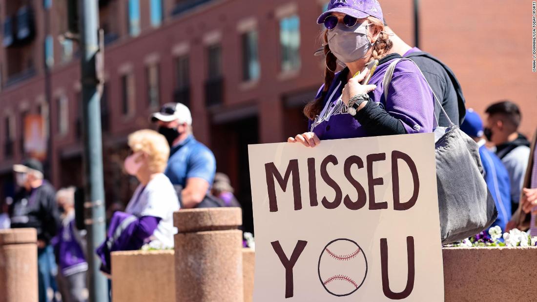 A fan holds a sign outside of Coors Field in Denver.