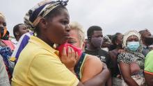 A woman cries as she waits for her son to arrive in Pemba on April 1, 2021, from the boat of evacuees from Palma. 