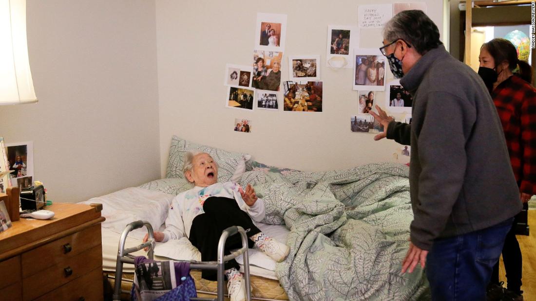 Yoshia Uomoto, 98, reacts as her son Mark Uomoto and niece Gail Yamada surprise her at her assisted-living facility in Seattle on March 30. Because of Covid-19 restrictions, it was their first in-person visit in a year.