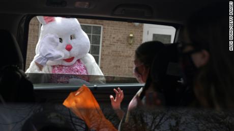 An Easter Bunny greets children during a Bunny Drive-Thru event outside in Alexandria, Virginia.
