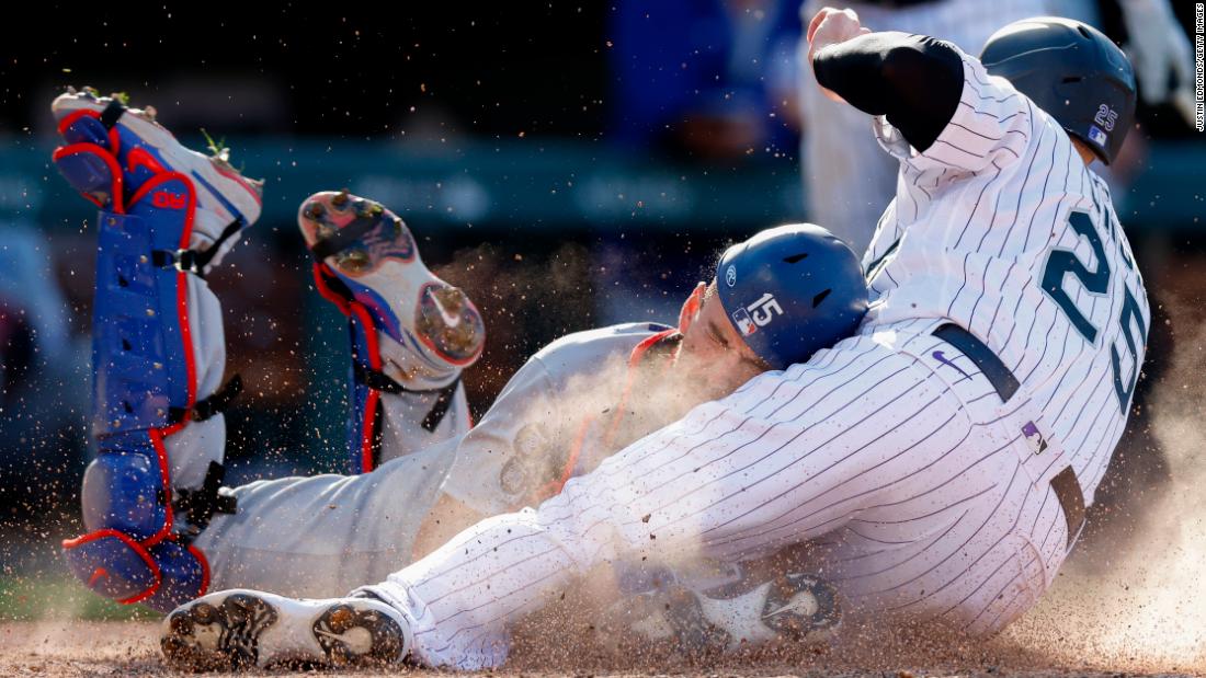 Colorado&#39;s C.J. Cron collides with Los Angeles Dodgers catcher Austin Barnes after sliding safely into home.