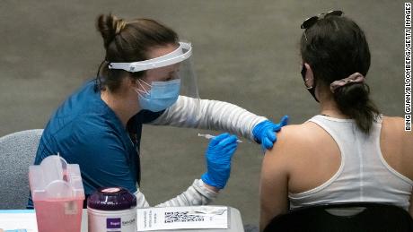 A healthcare worker administers a dose of the Pfizer-BioNTech Covid-19 vaccine inside the Viejas Arena on the campus of San Diego State University on Thursday.
