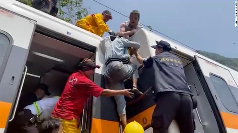 A passenger climbs out of the derailed train in Hualien County, Taiwan, on April 2. 