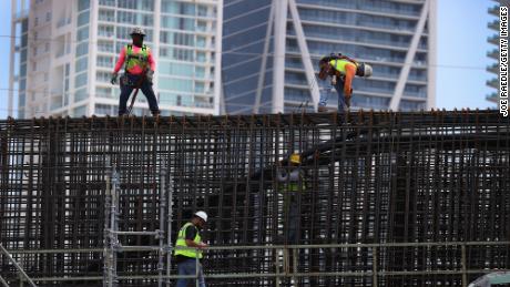 Construction workers build the &quot;Signature Bridge,&quot; replacing and improving a busy highway intersection at I-95 and I-395 on March 17, 2021 in Miami, Florida. The Florida Department of Transportation is building the project in partnership with the Miami-Dade Expressway Authority and its contractor, the Archer Western-de Moya Group Joint Venture. The infrastructure project will ease traffic congestion, connect communities with downtown neighborhoods, and provide an iconic bridge for Miami&#39;s skyline. The entire project is scheduled for completion in the fall of 2024 at the cost of $818 million. (Photo by Joe Raedle/Getty Images)