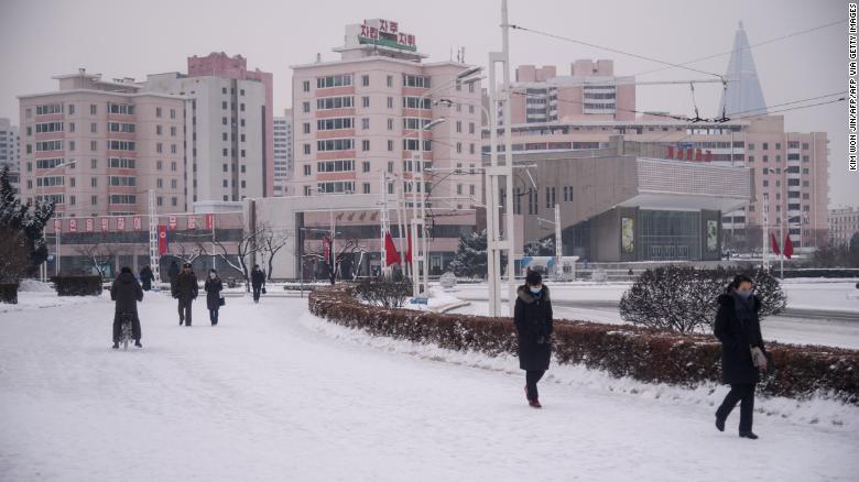People walk on a snow-covered street near the Arch of Triumph in Pyongyang on January 12.