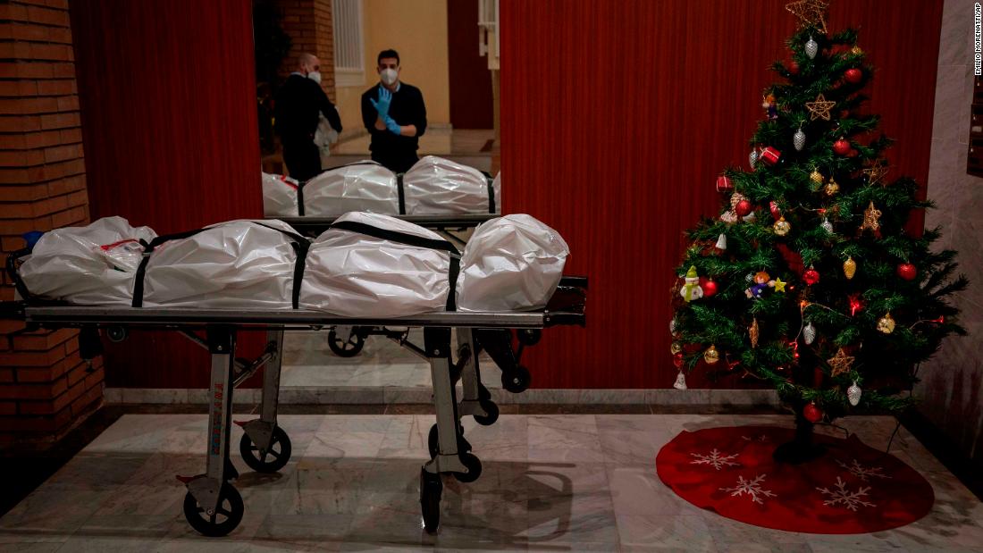 Mortuary workers take off their personal protective equipment after removing the body of a person who allegedly died of Covid-19 in Barcelona, Spain, on December 23.