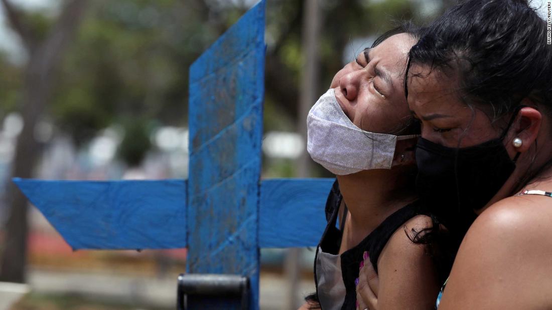 Kelvia Andrea Goncalves, left, is supported by her aunt Vanderleia dos Reis Brasao during the burial of her mother, Andrea dos Reis Brasao, in Manaus, Brazil, on January 17. Andrea, 39, died from Covid-19.