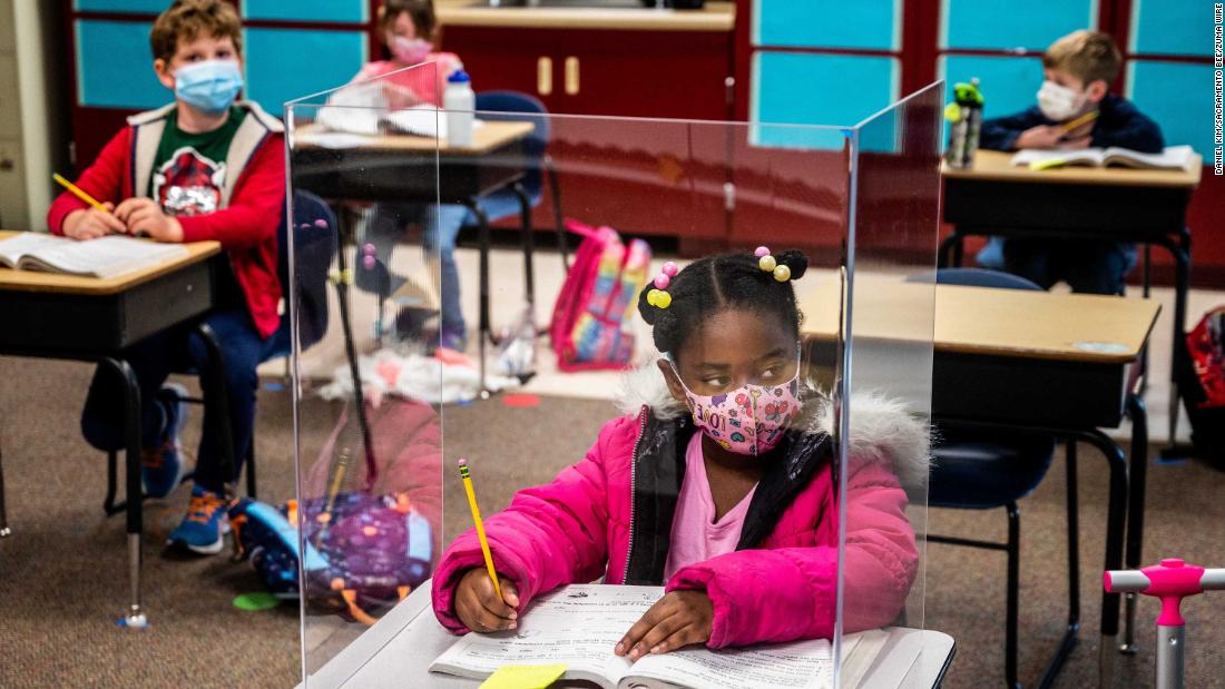 First-grader Sophia Frazier does her schoolwork behind a plastic divider at Two Rivers Elementary School in Sacramento, California, on March 8.