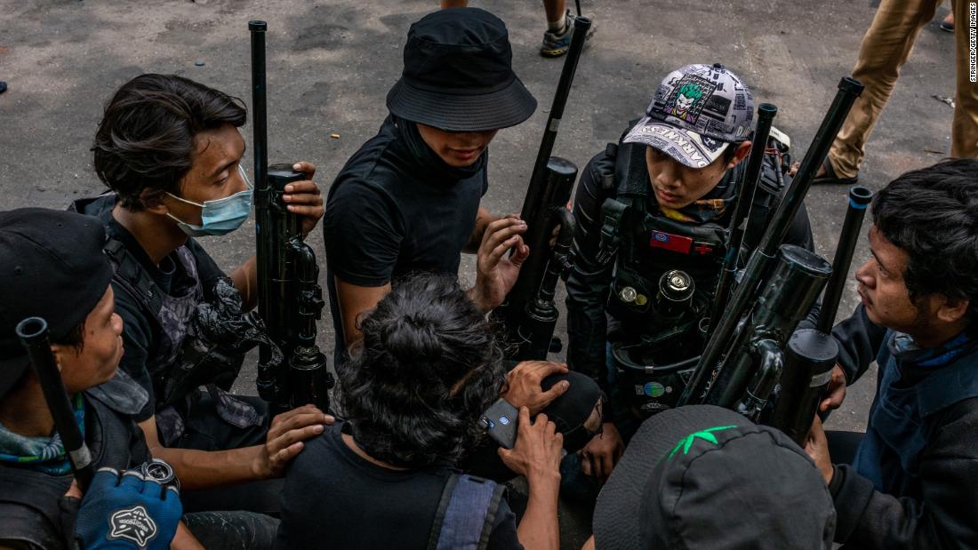 Protesters hold improvised weapons in Yangon on April 3.