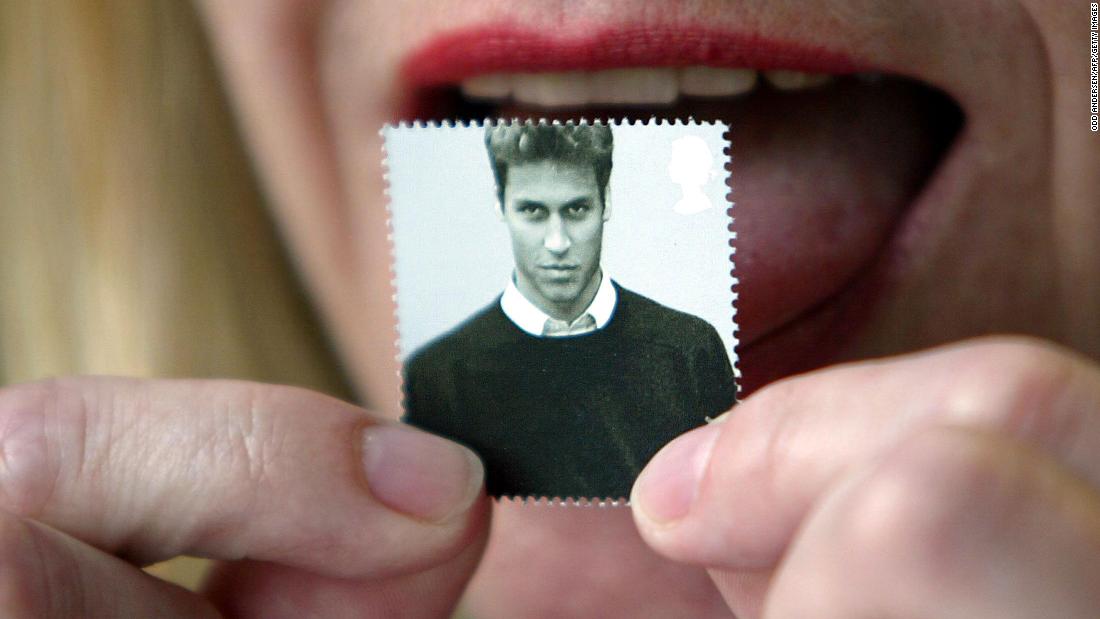 A London office worker licks a first-class stamp that was issued to mark Prince William&#39;s 21st birthday in 2003. Commemorative coins were also minted for the occasion.