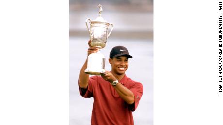 Woods holds up the U.S. Open trophy.