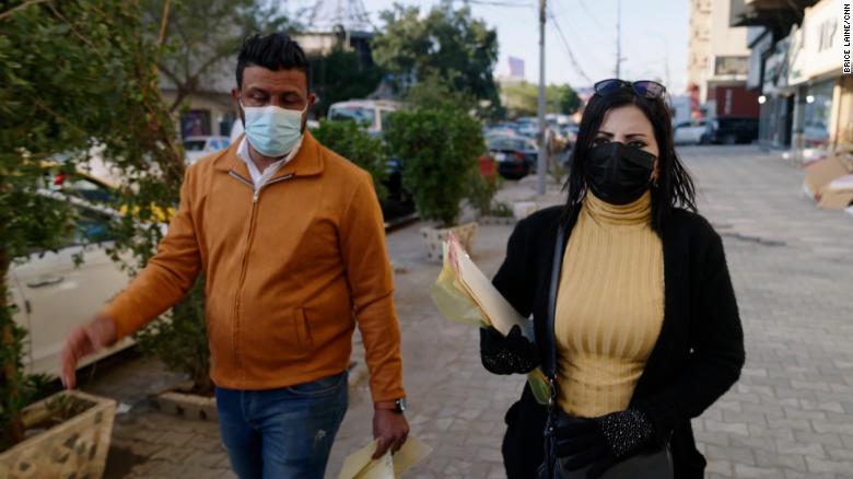 Enass Kareem, right, an activist for anti-drug awareness, canvasses a neighborhood with flyers in central Baghdad.