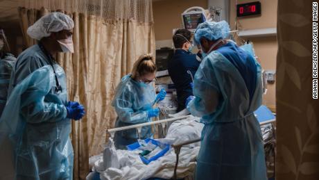 Healthcare workers tend to a patient with Covid-19 who is having difficulty breathing in a Covid holding pod at Providence St. Mary Medical Center in Apple Valley, California.