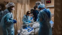 Healthcare workers tend to a patient with Covid-19 who is having difficulty breathing in a Covid holding pod at Providence St. Mary Medical Center in Apple Valley, California on January 11, 2021. 